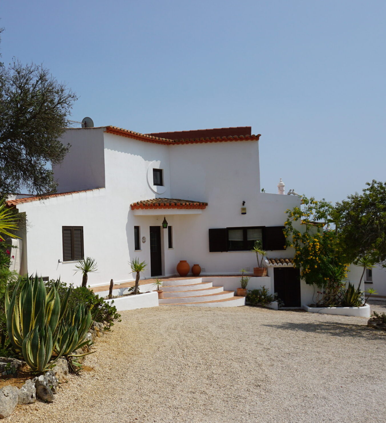 Two clean, white structures with plants at Quinta Da Aventura